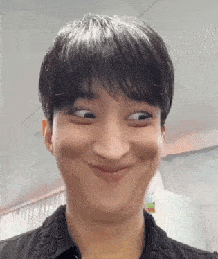 a man is making a funny face with his eyes closed .