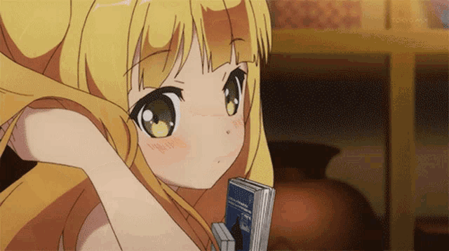 a girl with blonde hair is holding a book in her hand and tokyo mx is visible in the background