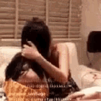 a woman is sitting on a couch holding a dog 's head .