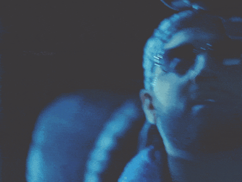 a close up of a person 's face in a blue light