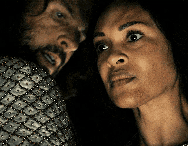 a man and woman are looking at each other in the dark