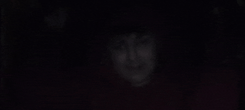 a woman 's face is visible in the dark .
