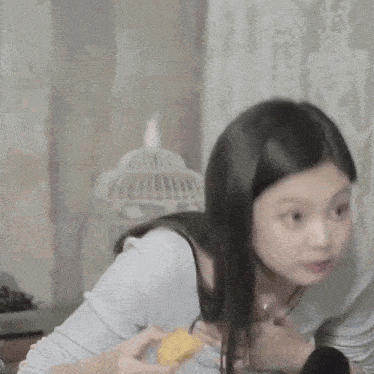 a woman wearing headphones and a necklace eating a piece of food