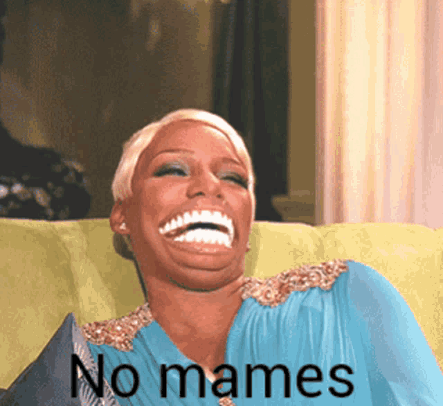 a woman is sitting on a green couch and laughing with the words no mames written below her