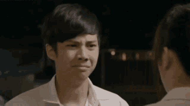 a young man is making a funny face while talking to a woman .
