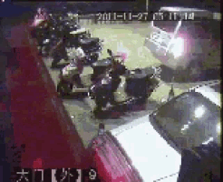 a row of scooters are parked in a parking lot at night