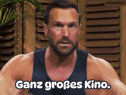 a man in a black tank top says ganz großes kino