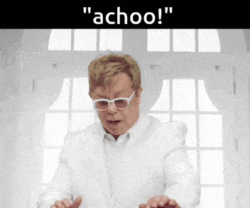 a man in a white suit says " achoo "
