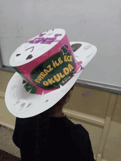 a person wearing a paper hat that says okulda on it