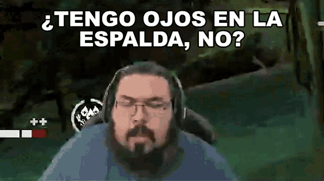 a man with glasses and a beard is wearing headphones and asking " tengo ojos en la espalda no "