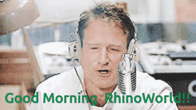 a man wearing headphones says " good morning rhinoworld " in green letters