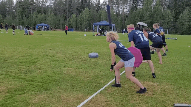 a group of people are running on a field and one of them has the number 7 on her shirt