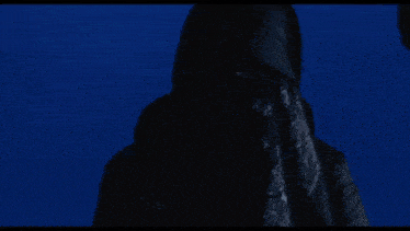 a man is driving a car in the dark with a tablet in his hand .
