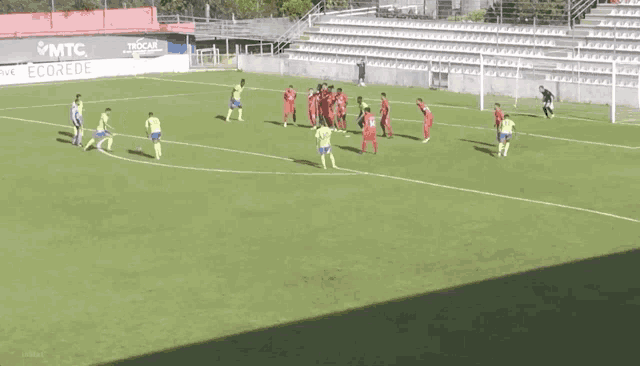 a group of soccer players are playing on a field with a sign that says ecorede
