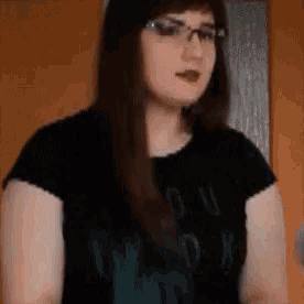 a woman wearing glasses and a black t-shirt with the word you on it