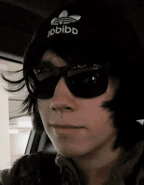 a person wearing sunglasses and a hat that says sobibb on it