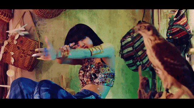 a woman is dancing in a room with a bird sitting on the floor .