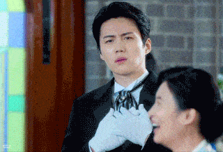 a man in a suit and tie is talking to a woman in a white glove .