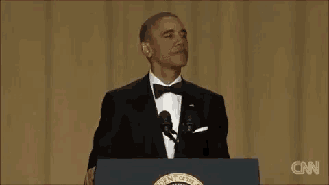 barack obama is giving a speech at a podium .