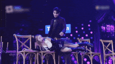 a woman is laying on a chair in front of a sign that says " com "