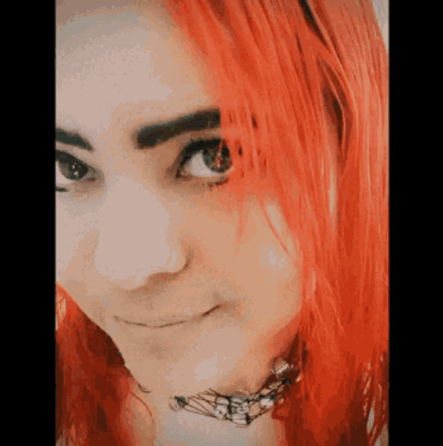 a close up of a woman 's face with red hair
