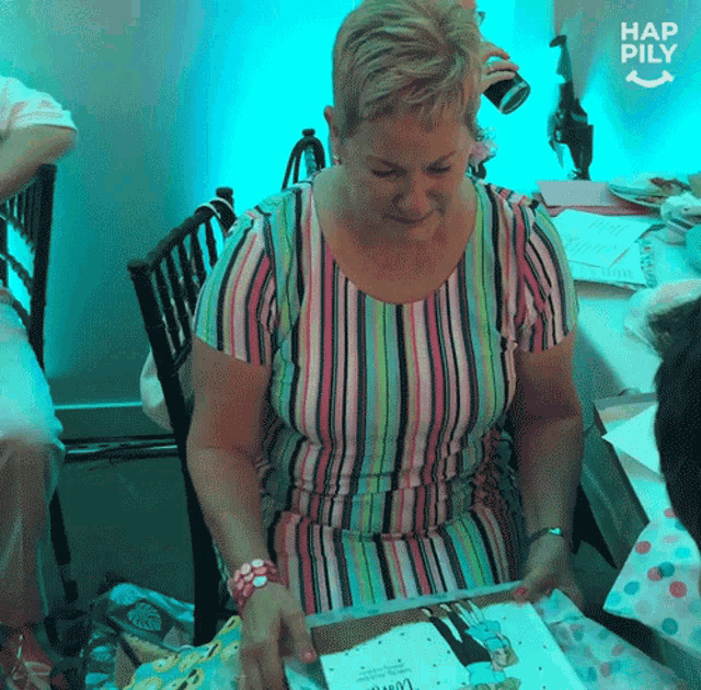 a woman in a striped shirt is looking at a book with the words hap pily on the bottom