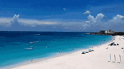 a beach with a lot of people on it and a blue sky