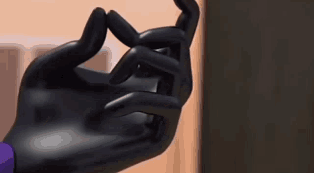 a close up of a person 's hand wearing a black glove and purple glove .