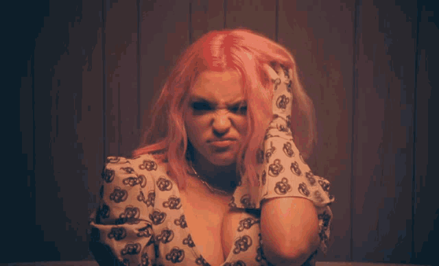 a woman with pink hair is wearing a white shirt with a leopard print