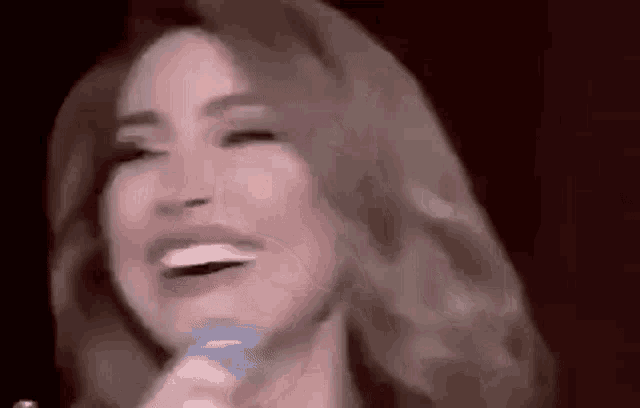 a close up of a woman singing into a microphone .