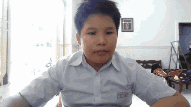 a young boy wearing a white shirt with a sticker on his chest that says ' t.c.c. '