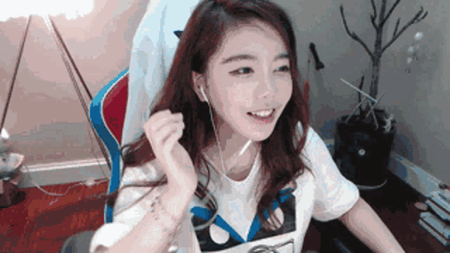a girl wearing headphones and a t-shirt with the letter x on it is smiling