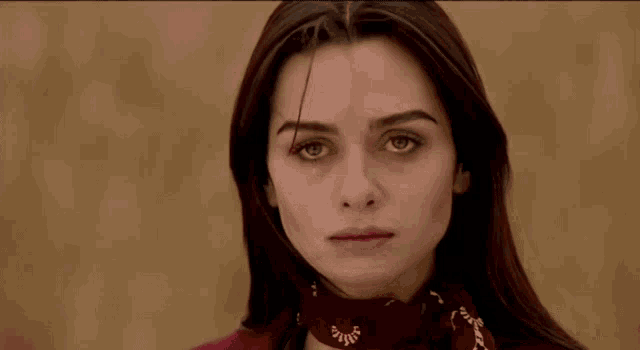 a close up of a woman wearing a red scarf around her neck .