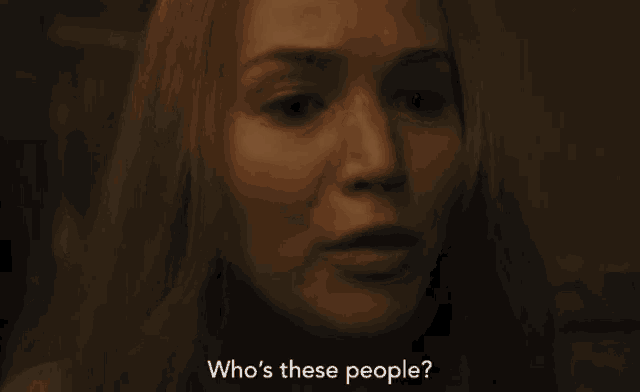 a close up of a woman 's face with the words `` who 's these people '' .