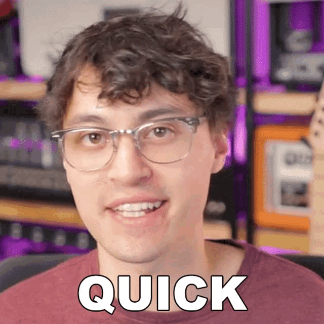 a man wearing glasses and a red shirt has the word quick written on his face