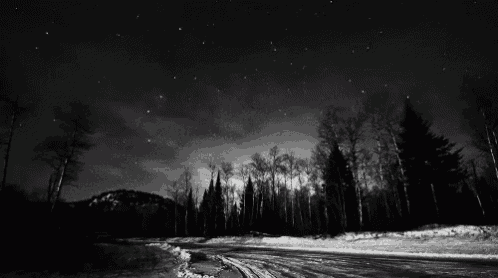 a black and white photo of a snowy road