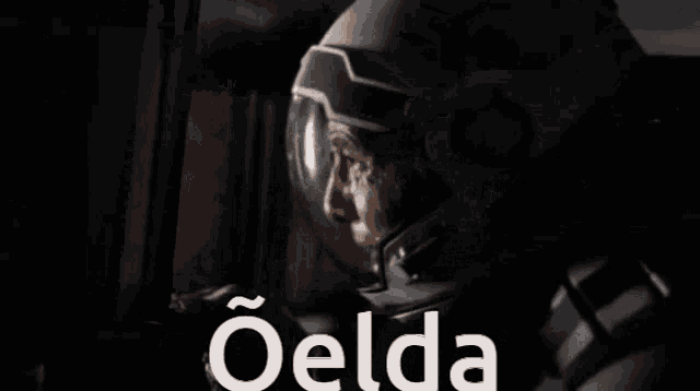 a man in a helmet is looking out a window and the word oelda is on the bottom of the image