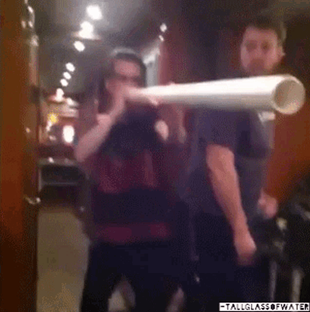 a man in a chicago shirt is holding a giant pipe