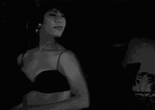 a black and white photo of a woman dancing with her arms outstretched .
