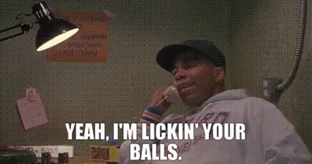 a man is talking on a cell phone and saying `` yeah , i 'm licking your balls ''