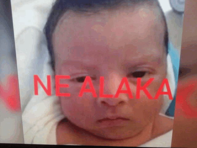 a close up of a baby 's face with the word ne alaika written on it