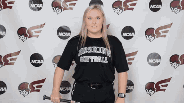 a woman wearing a shirt that says softball is holding a bat