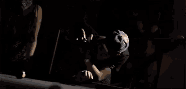 a man is playing pool in a dark room .