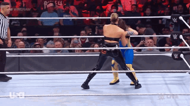 two women are wrestling in a wrestling ring with the words wweraw on the bottom of the screen