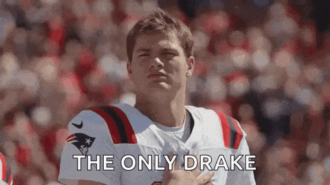 a football player is standing on the field with his hand on his chest .