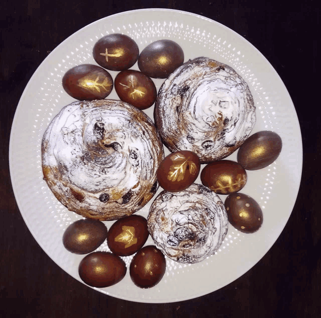 a white plate topped with pastries and eggs with gold crosses