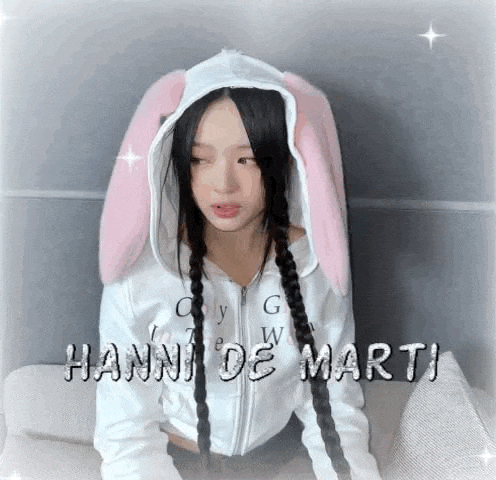 a woman wearing a white hoodie with pink bunny ears on her head .