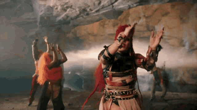 a woman with red hair is dancing with her hands in the air