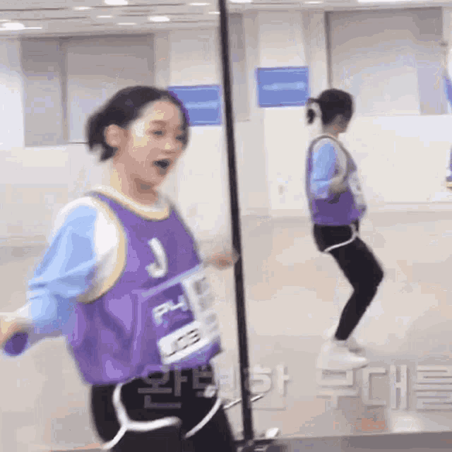 a young girl is jumping rope in front of a mirror .
