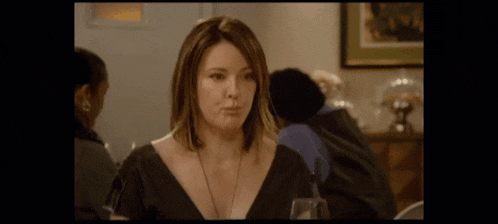 a woman in a black dress making a funny face